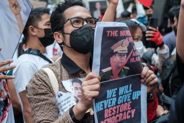 Protesters are shouting slogans while holding pro-democracy signs and pictures of deposed leader Aung San Suu Kyi as the crowd gathers in front of the Myanmar Embassy in Bangkok, Thailand, on 1 February 2023 (Photo: Reuters/Thomas De Cian/NurPhoto).