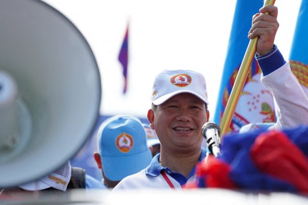 General Hun Manet, son of Cambodia's Prime Minister Hun Sen holds a party flag as he attends a kickoff of an election campaign rally for the upcoming national election in Phnom Penh, Cambodia, 1 July 2023 (Photo: Reuters/Cindy Liu).
