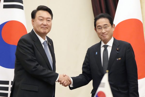 Japanese Prime Minister Fumio Kishida and South Korean President Yoon Suk Yeol shake hands ahead of their talks in Vilnius, Lithuania on 12 July 2023, on the sidelines of a NATO summit. (Photo: Kyodo)
