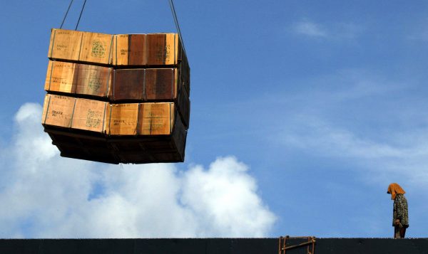 A worker loads Indonesian plywood onto a cargo ship headed for France on the southern coast of Kalimantan, Indonesia, 8 February 2004 (Photo: Reuters/Beawiharta).