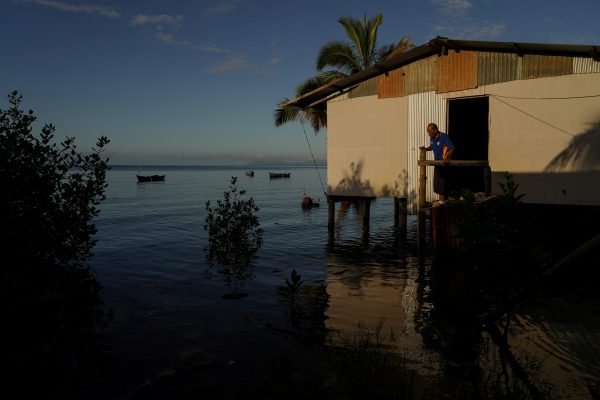 A local resident looks out at seawater flooding around his home at high tide in Veivatuloa Village, Fiji, 16 July 2022 (Photo: Reuters/Loren Elliott).