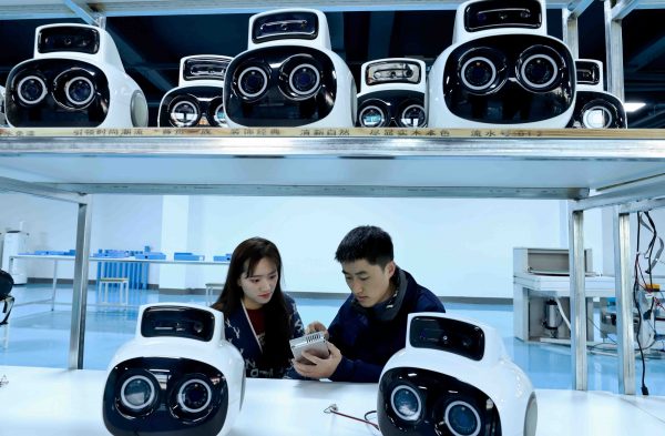 Technicians install a customized robot smart hard disk at an intelligent robot assembly and manufacturing workshop in Zhangye, China, 2 March 2023 (Photo: CFOTO via Reuters).