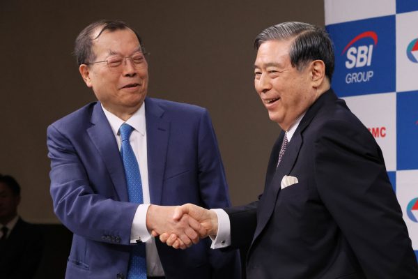 Frank Huang (L), President of Powerchip Semiconductor Manufacturing Corporation (PMSC), and Yoshitaka Kitao (R), Chairman, President & CEO of SBI Holdings shake hands during a news conference in Tokyo, Japan on 5 July 2023 (Photto: Masamine Kawaguchi/The Yomiuri Shimbun via Reuters Connect).