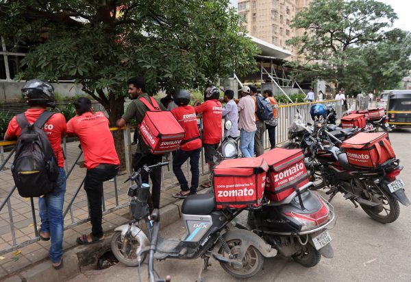 Gig workers wait in line to collect their delivery order outside a mall in Mumbai, India, 10 August 2023 (Photo: Reuters/Francis Mascarenhas).