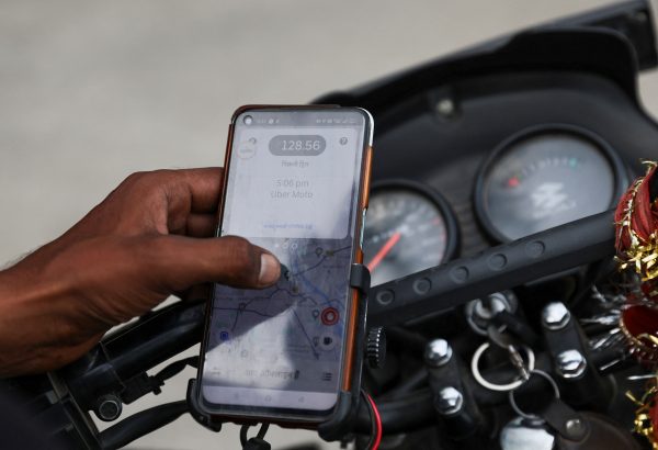 A motorbike driver uses the Uber mobile application for Uber Moto rides in New Delhi, India, 14 June 2023. (Photo: Reuters/Anushree Fadnavis)