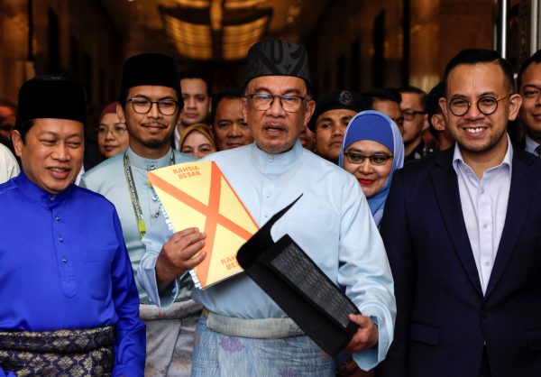 Malaysia's Prime Minister and Finance Minister Anwar Ibrahim holds the 2023 Malaysia's budget document at the Finance Ministry building, as he departs to the Parliament, in Putrajaya, Malaysia, 24 February 2023 (Photo: Reuters/Hasnoor Hussain).