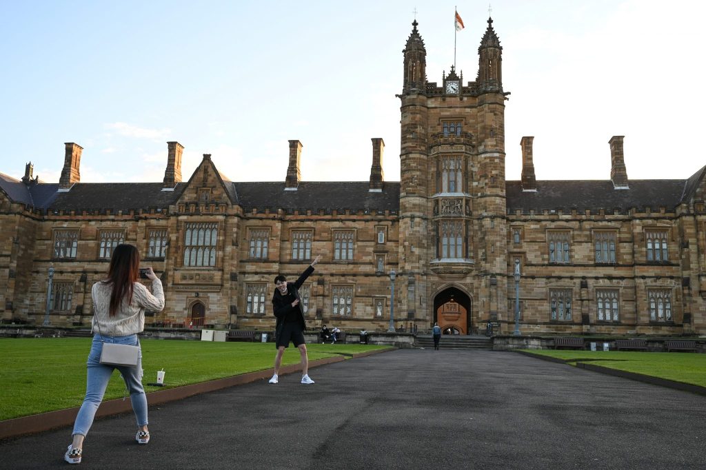 Chinese international students studying a Masters in Commerce at the University of Sydney take photos together on the university campus, during the COVID-19 outbreak, in Sydney, Australia, 11 August 2020 (Photo: Loren Elliott/ Reuters).