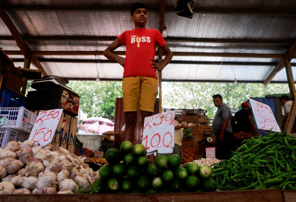 A vendor waits for customers at a stall at a main market, on the day President Ranil Wickremesinghe, who is also the island nation's finance minister, presents the annual budget in Colombo, Sri Lanka, 13 November 2023 (Photo: Reuters/Dinuka Liyanawatte).