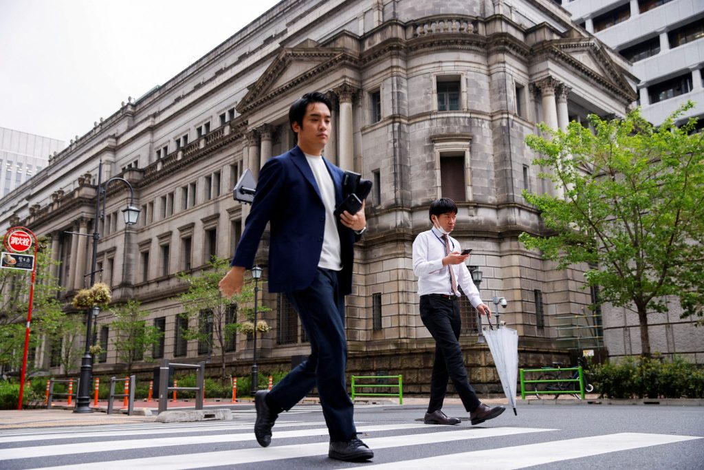 People walk in front of the bank of Japan building in Tokyo, Japan, 7 April 2023 (Photo: Reuters/Androniki Christodoulou/File Photo).