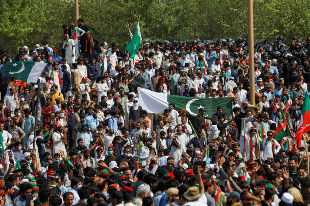 Supporters of the Pakistan Tehreek-e-Insaf (PTI) political party wave flags after they broke in to the Red Zone, during a protest march called by ousted Prime Minister Imran Khan, in Islamabad, Pakistan, 26 May 2022 (Photo: Reuters/Akhtar Soomro)