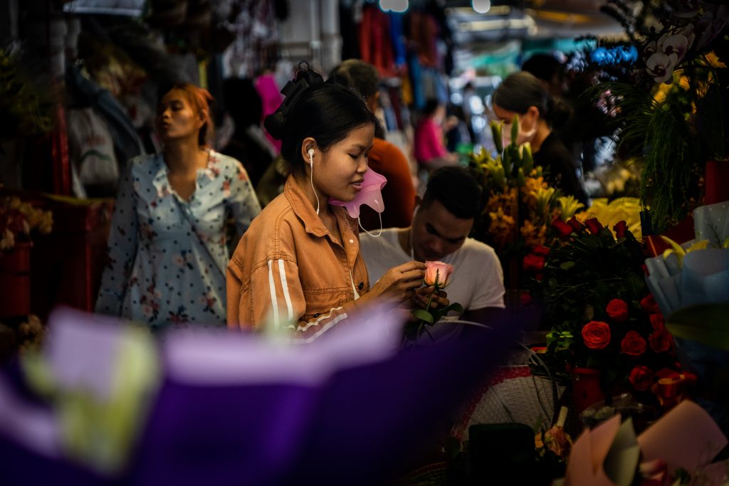 A street florist adds finishing touches to a single rose at Central Market in Phnom Penh, Cambodia, 4 September 2022 (Photo: Matt Hunt/SOPA Images via Reuters).
