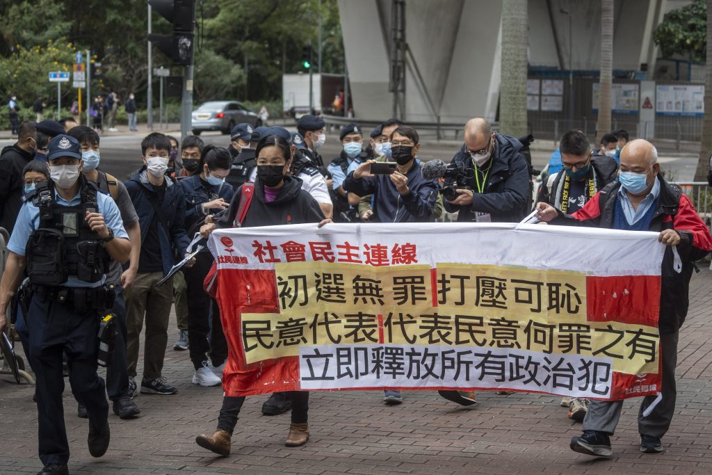 Pro-democracy protesters holding up a banner outside the West Kowloon Magistrates Court before the trail begins on the 47 Pro-Democracy Figures in Hong Kong, China, 6 February 2023 (Photo: Vernon Yuen/NurPhoto via Reuters).