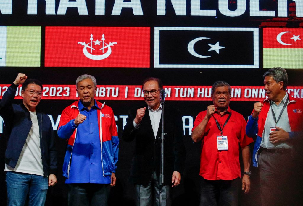 Malaysian Prime Minister Anwar Ibrahim and other leaders from rulling party chant during a press conference on the stines election in Kuala Lumpur, Malaysia, 12 August 2023 (Photo: Reuters/Hasnoor Hussain).