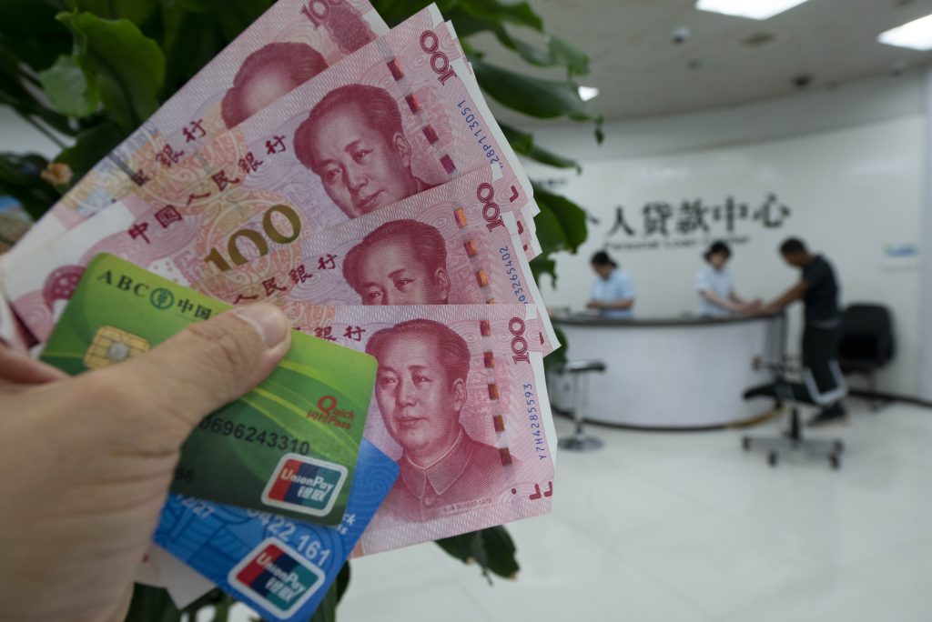 A staff member of a bank's personal loan centre receives business advice from a customer in Haian, East China's Jiangsu province, 21 August 2023 (Photo: Costfoto via Reuters).