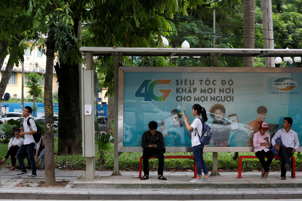 Internet users browse the Internet near an advertising billboard for 4G connection service at a bus stop in Hanoi, Vietnam, 29 August 2017 (Photo: Reuters/Kham).