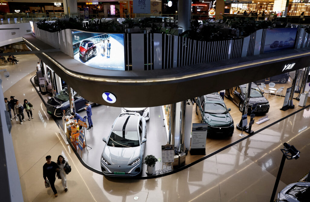 Electric vehicle (EV) models are displayed at the booths of Denza, a joint venture between Mercedes-Benz Group AG and BYD Auto, and Chinese EV maker Voyah, at a shopping mall in Beijing, China, 3 November 2023 (Photo: Reuters/Tingshu Wang).