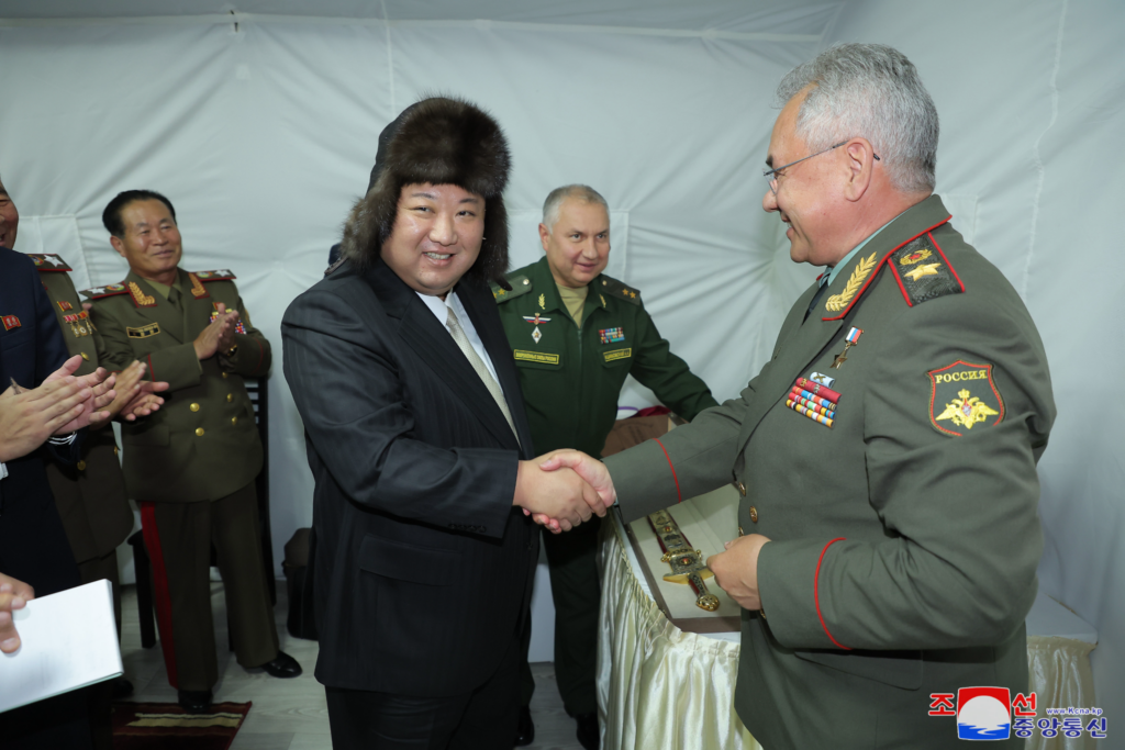 North Korean leader Kim Jong-un dons a fur hat while shaking hands with Russian defence minister Sergei Shoigu during a visit to the Russian Far East, 17 September 2023 (Image: Korean Central News Agency).