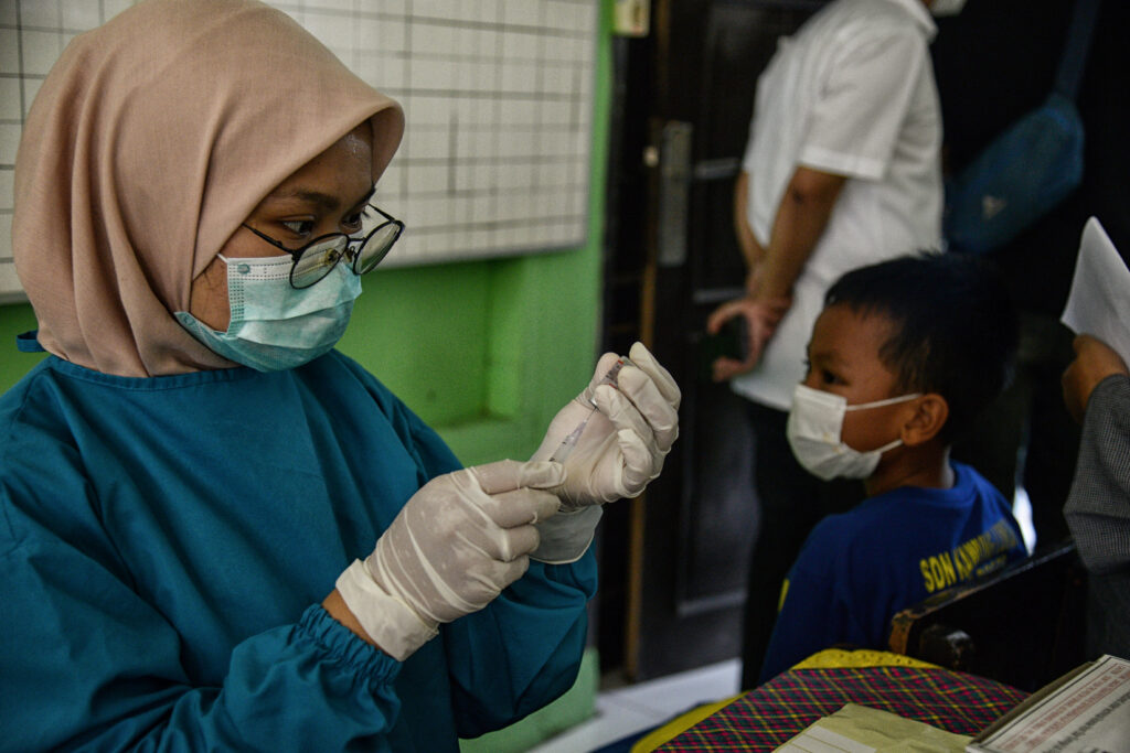 A health worker prepare administers a dose of Sinovac vaccine to a pupil during a vaccination against Covid-19 for children between 6-11 years old at a school in Bogor, Indonesia, 15 December 2021 (Photo: Reuters/Adriana Adie).