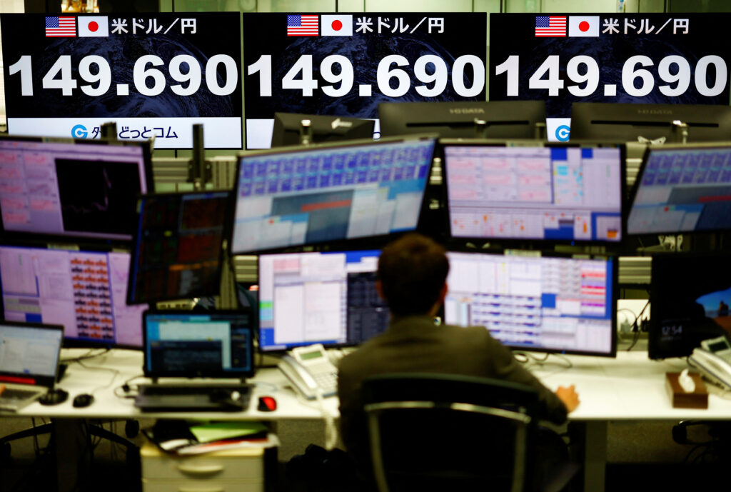 An employee of the foreign exchange trading company Gaitame.com works next to monitors showing the current Japanese Yen exchange rate against the U.S. dollar after the reports of the Bank of Japan ending eight years of negative interest rates, in Tokyo, Japan, 19 March 2024 (Photo: Reuters/Issei Kato).