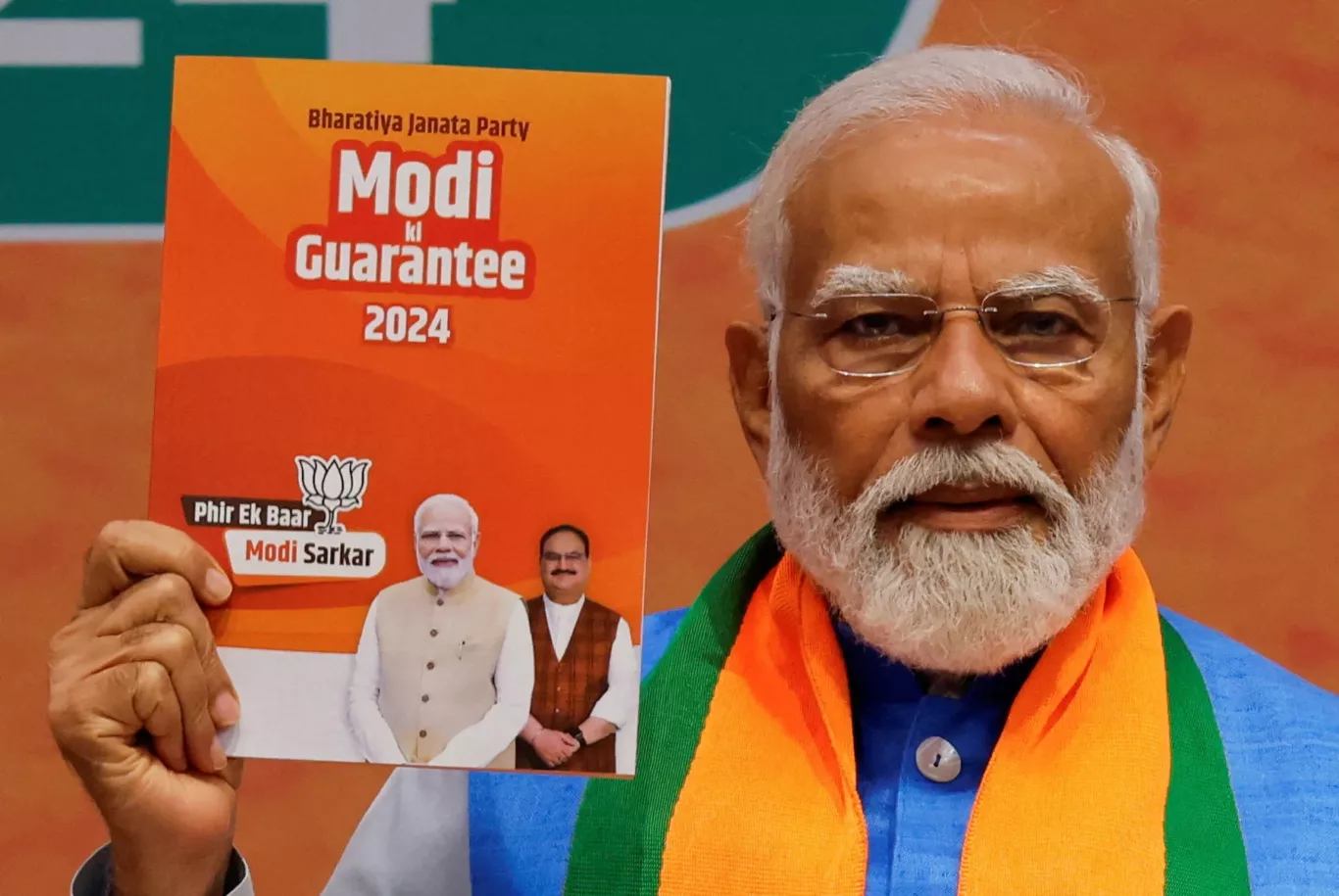 Indian Prime Minister Narendra Modi displays a copy of the ruling Bharatiya Janata Party's (BJP) election manifesto for the general election, in New Delhi, India, 14 April 2024 (Photo: Reuters/Adnan Abidi).