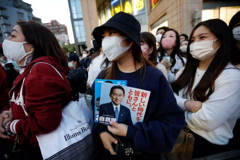 A voter holds a leaflet of Japan's ruling Liberal Democratic Party with cover photos of the Prime Minister and the party president Fumio Kishida as she waits for the speech by Kishida, on the last day of campaigning for the October 31 lower house election, amid the coronavirus disease (COVID-19) pandemic, in Tokyo, Japan, 30 October 2021. (Photo: Reuters/Issei Kato)