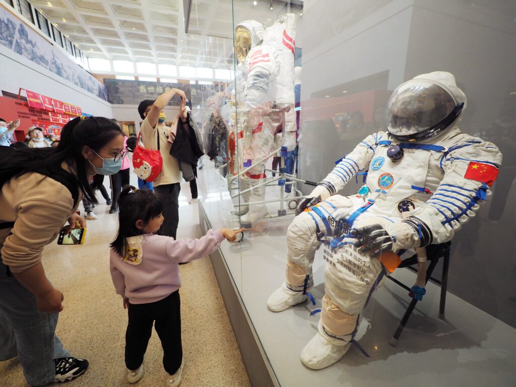Visitors view a 'capsule space suit' during an exhibition of 30 years of achievements in China's manned space program in Beijing, China, 23 April 2023 (Photo: CFOTO/Sipa USA via Reuters).