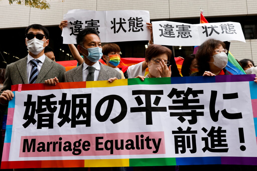Plaintiffs hold placards outside the court after hearing the ruling on same-sex marriage, in Tokyo, Japan, 30 November 2022 (Photo: Reuters/Kim Kyung-Hoon).